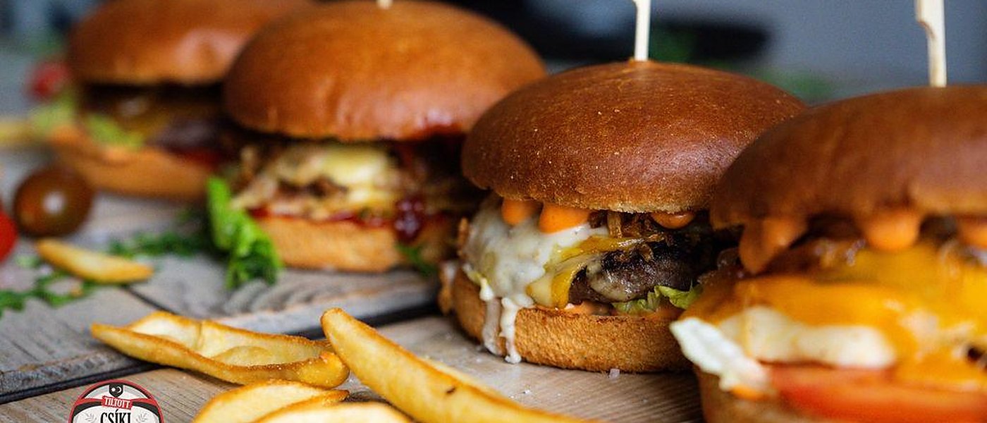 Burgeri și cartofi prăjiți pe o masă de lemn