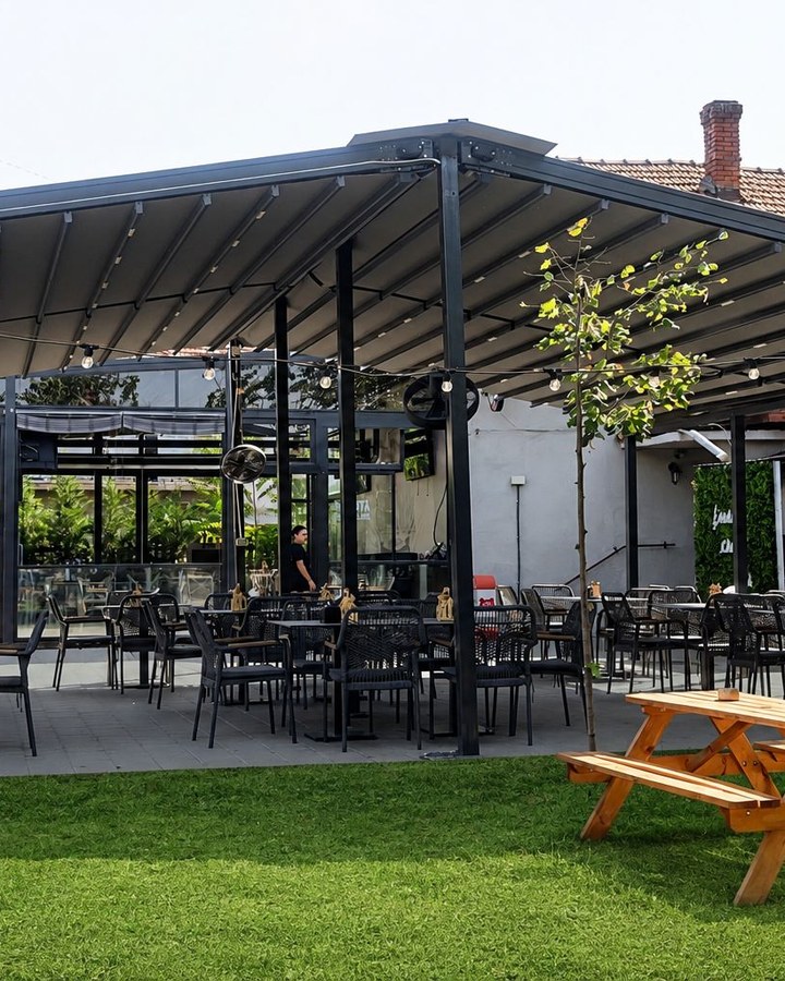 Grădina cu iarbă și mese de picnic